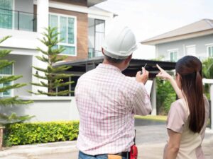 เจ้าของบ้านกำลังคุยกับผู้รับเหมา เพื่อตัดสินใจว่าจะต่อเติมบ้านที่ไหนดี