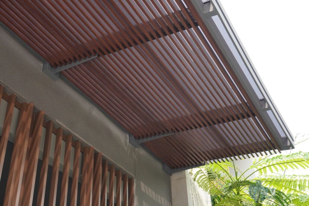 กันสาดบ้านทิศใต้ใช้หลังคาโปร่งแสงที่ป้องกันความร้อนและระแนงไม้ ช่วยให้บ้านไม่มืดเกินไป